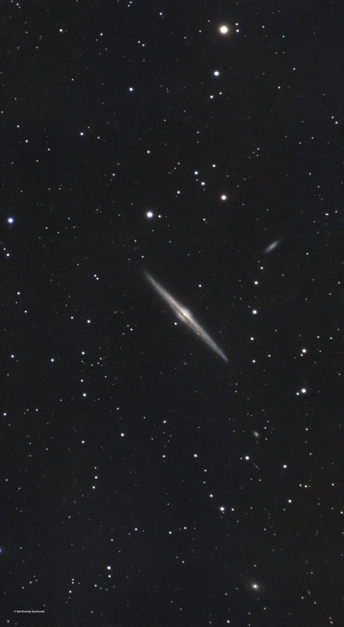 Galaktyka spiralna NGC 4565 widziana z boku, cienka jak ostrze igły